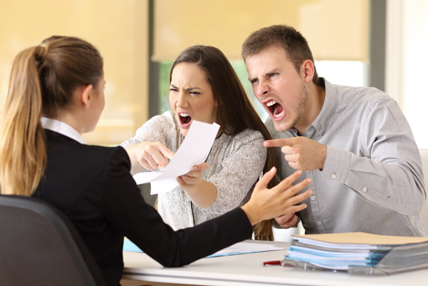 a couple arguing with a female behind a desk