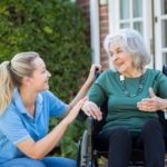 nurse caring for elderly lady in wheelchair
