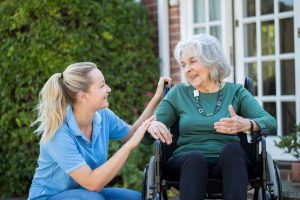 nurse talking to elderly lady in wheelchair
