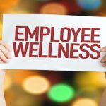 hands holding sign saying employee wellness