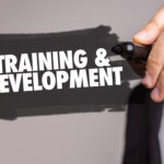 A hand holding a sign saying training and development